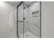 Walk-in shower featuring sleek glass doors and tiled walls with an integrated shampoo niche at 1021 S Almar Cir, Mesa, AZ 85204