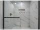 Shower features sleek glass doors, tiled walls with a built-in shampoo niche, and matte black fixtures at 1021 S Almar Cir, Mesa, AZ 85204