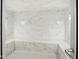 Contemporary bathroom boasts elegant marble walls, tile flooring, and built-in bench at 114 W Adams St # 505, Phoenix, AZ 85003