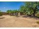 Expansive backyard with a play structure, patio seating, and mature trees at 1225 S 160Th Ln, Goodyear, AZ 85338