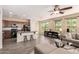 Open concept kitchen and living space featuring dark wood cabinets, large island and modern furniture at 1225 S 160Th Ln, Goodyear, AZ 85338
