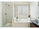 Bright bathroom featuring a glass shower, large tub, and unique glass block window at 1228 E Mountain Vista Dr, Phoenix, AZ 85048