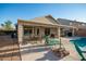 Backyard patio featuring a covered seating area, dining table, and lounge chairs near the pool at 12374 W Hopi St, Avondale, AZ 85323