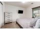 Inviting bedroom with a dresser, mounted television, and cozy bedding, offering a comfortable space at 12374 W Hopi St, Avondale, AZ 85323