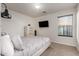 Bright bedroom with a mounted television, window with blinds, and modern furniture, offering a cozy retreat at 12374 W Hopi St, Avondale, AZ 85323
