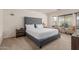Well-lit bedroom with a tufted headboard, side tables, and a cozy seating area at 12374 W Hopi St, Avondale, AZ 85323
