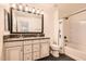 Well-lit bathroom with double vanity, granite countertops, and a shower-tub combination at 128 E Bluejay Dr, Chandler, AZ 85286