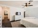 Comfortable bedroom with neutral tones, ceiling fan, and a glimpse into the en-suite bathroom at 128 E Bluejay Dr, Chandler, AZ 85286