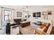 Cozy living room with a large black leather couch, wood chest, and open floor plan at 128 E Bluejay Dr, Chandler, AZ 85286