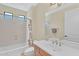 Bathroom with a single sink vanity, large mirror, wood cabinets and a bathtub and shower combination at 13450 E Via Linda -- # 2022, Scottsdale, AZ 85259