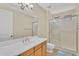 Bathroom with a single sink vanity, large mirror, wood cabinets and a walk in shower at 13450 E Via Linda -- # 2022, Scottsdale, AZ 85259