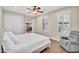 Bedroom with wood flooring, plantation shutters, ceiling fan and an opening into the living room at 13450 E Via Linda -- # 2022, Scottsdale, AZ 85259