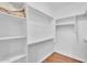 Walk-in closet with custom white shelving and wood-look flooring, providing ample storage space at 13450 E Via Linda -- # 2022, Scottsdale, AZ 85259