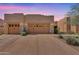 Inviting home exterior features a three car garage with stone accents and desert landscaping at 13450 E Via Linda -- # 2022, Scottsdale, AZ 85259