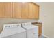 Spacious laundry room with full-size washer and dryer, wood cabinets and granite countertops at 13450 E Via Linda -- # 2022, Scottsdale, AZ 85259