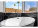 Modern bathroom featuring a sleek standalone tub, black fixtures, and stylish black tile accents at 14418 S 42Nd St, Phoenix, AZ 85044
