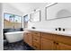 Stylish bathroom featuring a soaking tub, modern vanity with double sinks, and black hexagonal tile flooring at 14418 S 42Nd St, Phoenix, AZ 85044
