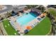 Aerial view of the community pool featuring lounge chairs, tables, umbrellas, and ramada, and grassy area at 14657 W Sand Hills Rd, Surprise, AZ 85387