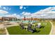 Community pool area featuring a large pool, lounge chairs, tables, umbrellas, and outdoor seating under shaded ramadas at 14657 W Sand Hills Rd, Surprise, AZ 85387