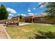 Spacious backyard with lush grass, desert landscaping, cozy seating area, and shaded patio for outdoor enjoyment at 15088 W Coolidge St, Goodyear, AZ 85395
