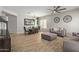 Open-concept dining and living area with wood-look tile floors, a modern light fixture, and comfortable seating at 15088 W Coolidge St, Goodyear, AZ 85395