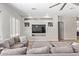Cozy living room with a large sectional sofa, wood-look tile floors, a ceiling fan, and built-in shelving at 15088 W Coolidge St, Goodyear, AZ 85395
