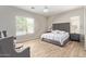 Serene main bedroom with tufted headboard, wood-look flooring, and natural light at 15088 W Coolidge St, Goodyear, AZ 85395