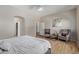 Comfortable main bedroom boasts wood floors, ceiling fan, two chairs, and an ensuite entrance at 15088 W Coolidge St, Goodyear, AZ 85395