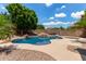 Backyard featuring a pristine pool, tranquil waterfall feature, and desert landscaping for a serene outdoor oasis at 15088 W Coolidge St, Goodyear, AZ 85395
