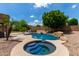 Inviting pool and spa surrounded by desert landscaping, palm trees, and a spacious patio area for relaxation at 15088 W Coolidge St, Goodyear, AZ 85395