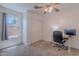 Carpeted bedroom featuring a ceiling fan, window, and desk area at 17403 N 16Th Pl, Phoenix, AZ 85022
