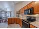 A well-lit kitchen features stainless steel appliances and wood cabinetry, with a view into the dining area at 17403 N 16Th Pl, Phoenix, AZ 85022