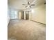 Spacious bedroom with neutral carpet, ceiling fan, and natural light from the louvered window at 17841 N Del Webb Blvd, Sun City, AZ 85373