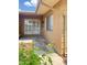 Charming patio area with tan siding, two windows, and a decorative screen door at 17841 N Del Webb Blvd, Sun City, AZ 85373