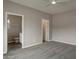 Large bedroom with gray carpet, open doors to the bathroom and closet at 22352 W Gamble Ln, Wittmann, AZ 85361