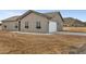 Exterior of the home with an attached garage, showcasing the neutral color scheme and desert surroundings at 22352 W Gamble Ln, Wittmann, AZ 85361