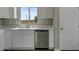 Close up on kitchen with stainless steel dishwasher, white cabinets and view from the window at 22352 W Gamble Ln, Wittmann, AZ 85361