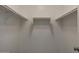 Bright, empty walk-in closet with white walls and wooden rods for hanging clothes at 22352 W Gamble Ln, Wittmann, AZ 85361