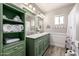 Stylish bathroom with dual sink vanity, unique green cabinetry, and decorative fixtures at 253 N Fraser Dr, Mesa, AZ 85203