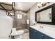 Bathroom with a single sink vanity, framed mirror, and glass enclosed tile shower at 253 N Fraser Dr, Mesa, AZ 85203