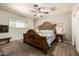 Bedroom featuring an ornate wooden headboard, ceiling fan, and ample natural light at 253 N Fraser Dr, Mesa, AZ 85203