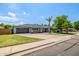 Charming single-story home with a gray exterior, well-manicured lawn, mature trees, and an attached two-car garage at 253 N Fraser Dr, Mesa, AZ 85203