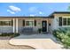 Inviting front porch with a swing, beautiful landscaping, and a stylish black front door at 253 N Fraser Dr, Mesa, AZ 85203
