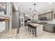 Well-appointed kitchen with granite island and countertops, gray cabinets, and barstool seating at 253 N Fraser Dr, Mesa, AZ 85203