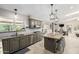 Open-concept kitchen with stainless appliances, granite countertops, and seamless flow to dining area at 253 N Fraser Dr, Mesa, AZ 85203