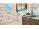 Well-designed laundry room with modern cabinets, granite countertop, stylish wallpaper, and tiled flooring at 2877 E Lucky Horseshoe Ln, San Tan Valley, AZ 85140