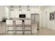 Bright kitchen featuring stainless steel appliances, modern white cabinets, and breakfast bar seating at 2897 E Lucky Horseshoe Ln, San Tan Valley, AZ 85140