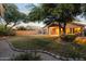 Well-maintained backyard with lush lawn, mature trees, covered patio, and beautiful desert landscaping at 300 W Cardinal Way, Chandler, AZ 85286
