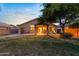 Spacious backyard featuring a covered patio, grassy lawn, mature tree and perimeter block fencing at 300 W Cardinal Way, Chandler, AZ 85286
