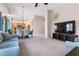 Spacious living room with plush carpeting, ceiling fan, and open floorplan to dining and kitchen at 300 W Cardinal Way, Chandler, AZ 85286